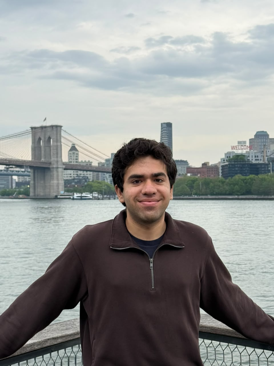 Dhruv by the waterfront with the Brooklyn Bridge in the background