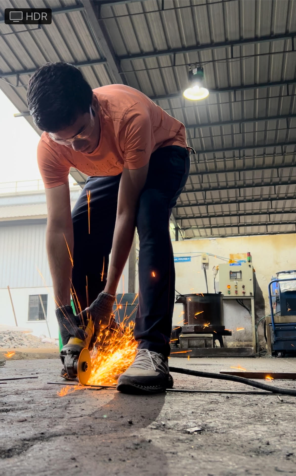 Dhruv working with an angle grinder in a workshop